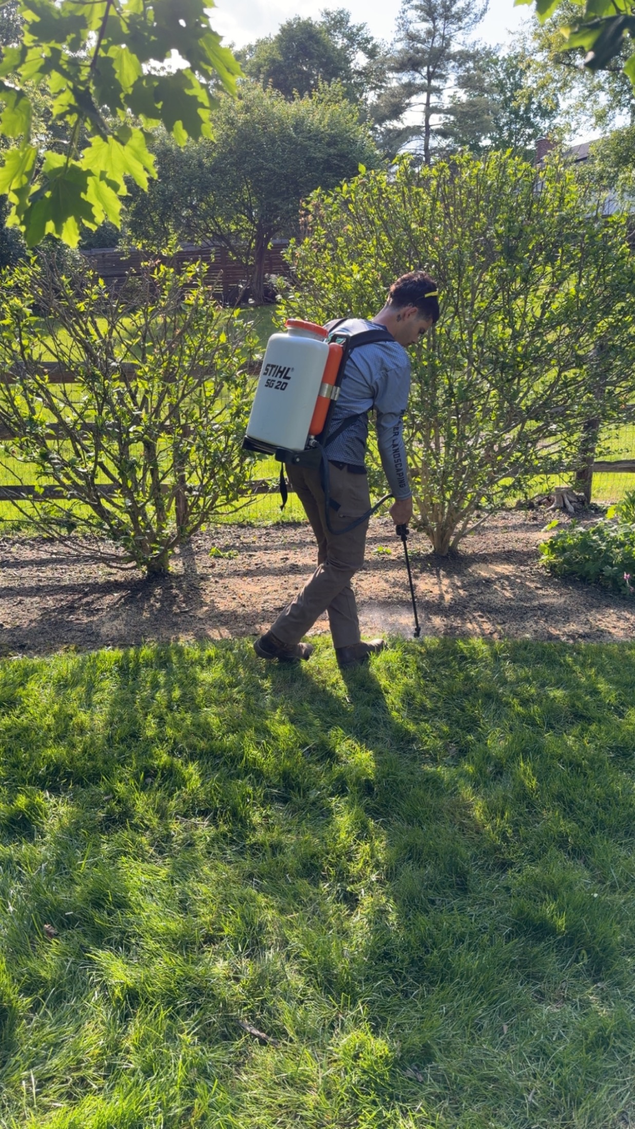 Mercer crew member applying landscape maintenance treatment